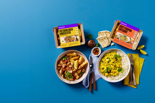 Two prepared winter meals with packaging on a blue background